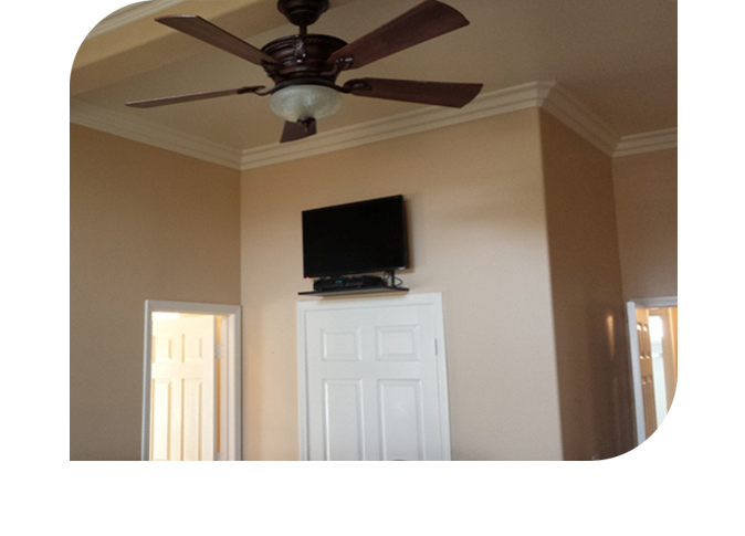 A room with a tv and ceiling fan